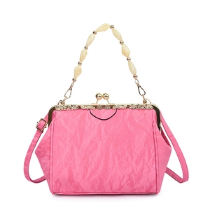 Detailed shot of pink pleated shell bag with gold clasp and beaded top handle strap