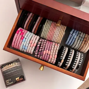 Sesame-colored high-elasticity hair ties set in a premium transparent storage box
