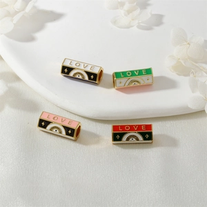 Detail of colorful enamel LOVE beads in white, green, pink, and red for DIY jewelry