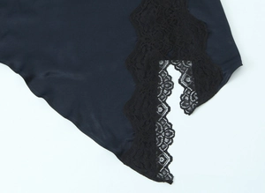 Detail von Seiden-Satin-Stoff und feiner schwarzer Spitze an einem dunkelblauen Kleid