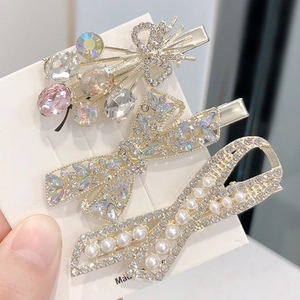 Three-piece hair clip set with sparkling bow designs, pearls, and colorful crystals