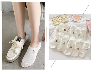Detail of white cotton low-cut socks with cartoon embroidery and non-slip design