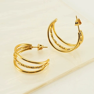 Elegant gold double-layer twisted stainless steel hoop earrings for women on reflective surface