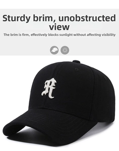 Close-up of gothic letter R 3D embroidery on classic black baseball cap with curved brim