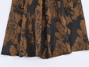 Vue détaillée du tissu jacquard floral marron et noir brillant à la texture élégante