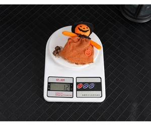Detail showing a 12g lightweight Halloween pumpkin ghost figure with a witch hat on a scale