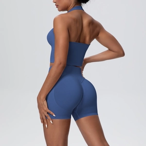 Detail of high-waisted seamless biker shorts and halter sports bra in navy blue