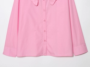 Close-up of pink long-sleeved shirt featuring detailed embroidery and Peter Pan collar