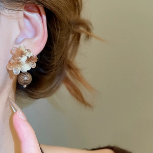 Gros plan de boucles d'oreilles fleur en résine vintage avec perles en bois