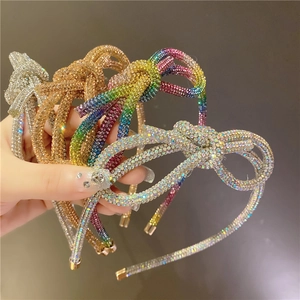 Close-up of four sparkling rhinestone headbands with bow details in diverse vibrant colors