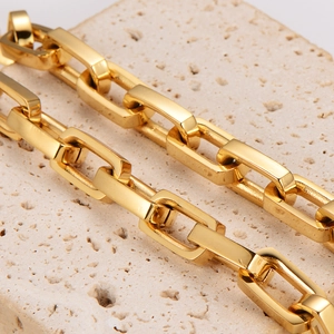 Minimalist gold stainless steel bamboo square link chain on a natural beige stone