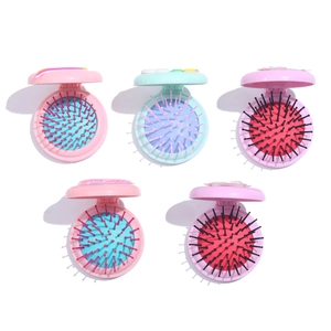 Detailed flat lay of colorful portable folding hairbrushes with built-in mirrors