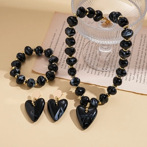 Detail of black marble acrylic heart pendant necklace with gold metal spacer beads