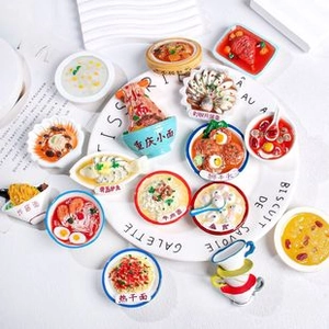 Top-down view of a 15-piece miniature food magnet set on a white decorative plate