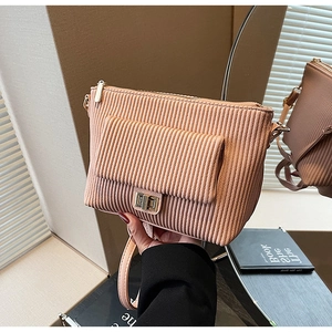 Detail of pink corduroy shoulder bag showing vertical texture and gold twist lock