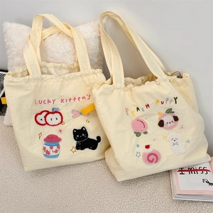 Close-up of cute dog and cat embroidery on beige drawstring canvas tote bags