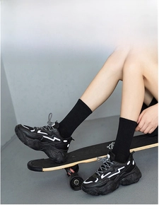 Close-up of black platform sneakers with white wave stripes and street style socks