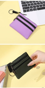 Détail de porte-monnaie en tissu à triple fermeture éclair avec porte-clés en violet et vert