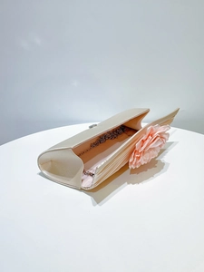 Elegant pleated evening clutch bag with pink flower detail and chain strap for parties.