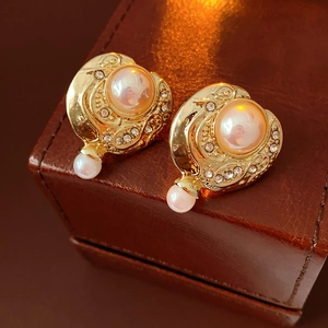 Gros plan détaillé de boucles d'oreilles vintage avec perles et strass sur cuir brun