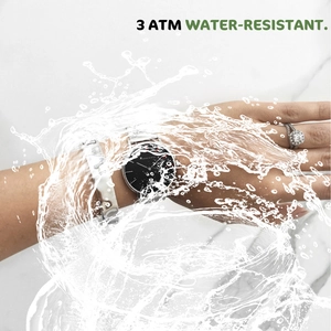 Close-up of quartz watch with 3 ATM water resistance splashing in water on marble background