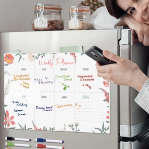 Close-up of magnetic acrylic weekly planner with floral pattern attached to a refrigerator