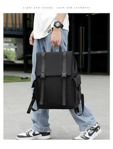 Close-up of black tactical nylon backpack with buckle straps in an outdoor street setting