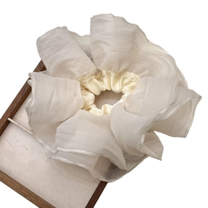 Oversized French style cream pleated mesh scrunchie displayed on a wooden tray