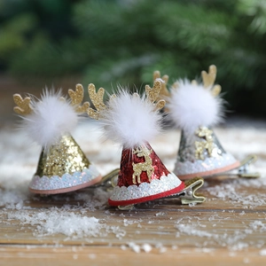 Glittering Christmas reindeer antler hair clips with sequin hats on snowy wood background