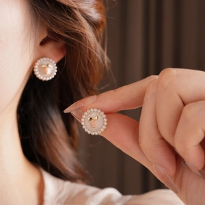 Detail of golden bow earrings with pearl inlay in a vintage oil painting style