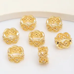 Dettaglio macro di perle distanziatrici placcate in oro 14K con zirconi micro-incastonati