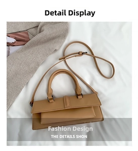 Close-up of khaki brown handbag featuring dual top handles and adjustable shoulder strap