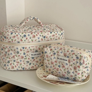 Macro shot of quilted corduroy makeup bags with floral print and white brand label