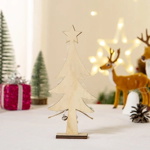 Detail of wooden Christmas tree decor with star topper and bells on a cozy festive desk