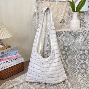 Close-up of white crochet tote bag with colorful stripes and delicate lace texture