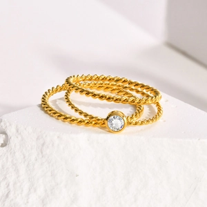 Dreiteiliges Set gedrehter 18K vergoldeter Ringe mit einem funkelnden Zirkonia-Stein