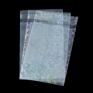 Macro detail of three clear resealable bags with laser star patterns on black background