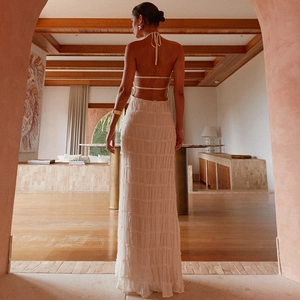 Detail of white backless maxi dress with smocked fabric texture and lace-up neck straps