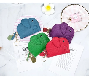 Flat lay of colorful leather elephant coin purses with tassels and keychain accessories
