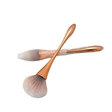 Detail of round head concealer lip brush with golden handle and protective mesh sleeve