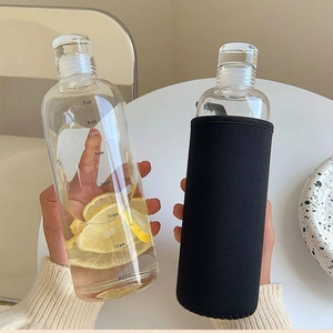 Detail view of transparent water bottle with time markers and black fabric sleeve