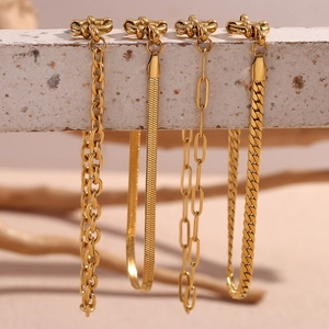 Detail of four 18K gold plated chains including snake and Cuban styles on stone base