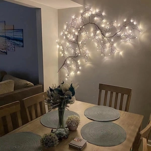 Warm white LED branch lights on a grey wall creating a cozy dining room atmosphere