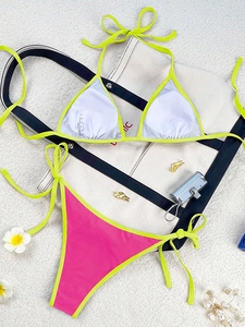 Detailed flat lay of a two-piece bikini with fluorescent yellow straps and S size tag