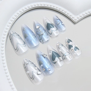 Dreamy pearlescent blue press-on nails with silver hearts and starburst diamond accents