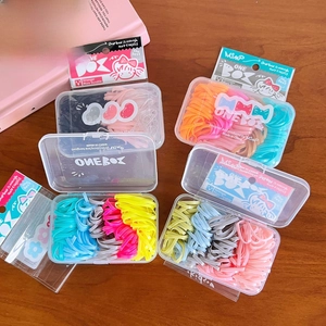 Macro di 100 elastici per capelli colorati in una scatola di plastica trasparente