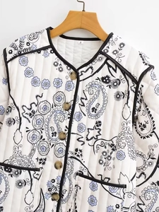 Detail of vintage paisley printed quilted jacket with black piping and buttons