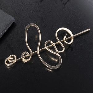 Abstract golden winding hair stick on black wet background with elegant water droplets