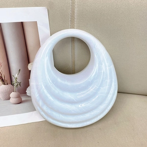 Acrylic evening bag with white pearlescent marble texture and wavy pattern
