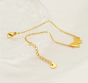 Detailed macro view of gold butterfly pendant with polished finish and adjustable chain